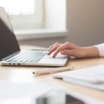 Hands typing on laptop